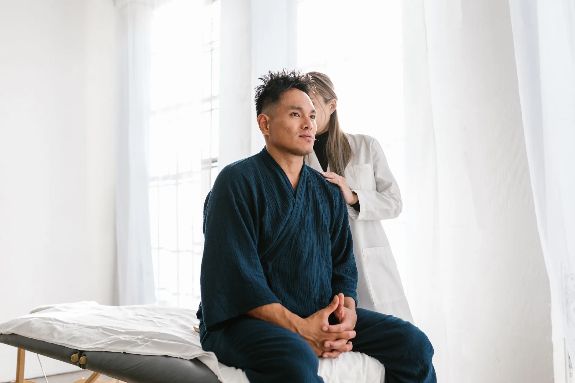 A doctor examines a man seated on an exam table during an evaluation for chronic groin pain