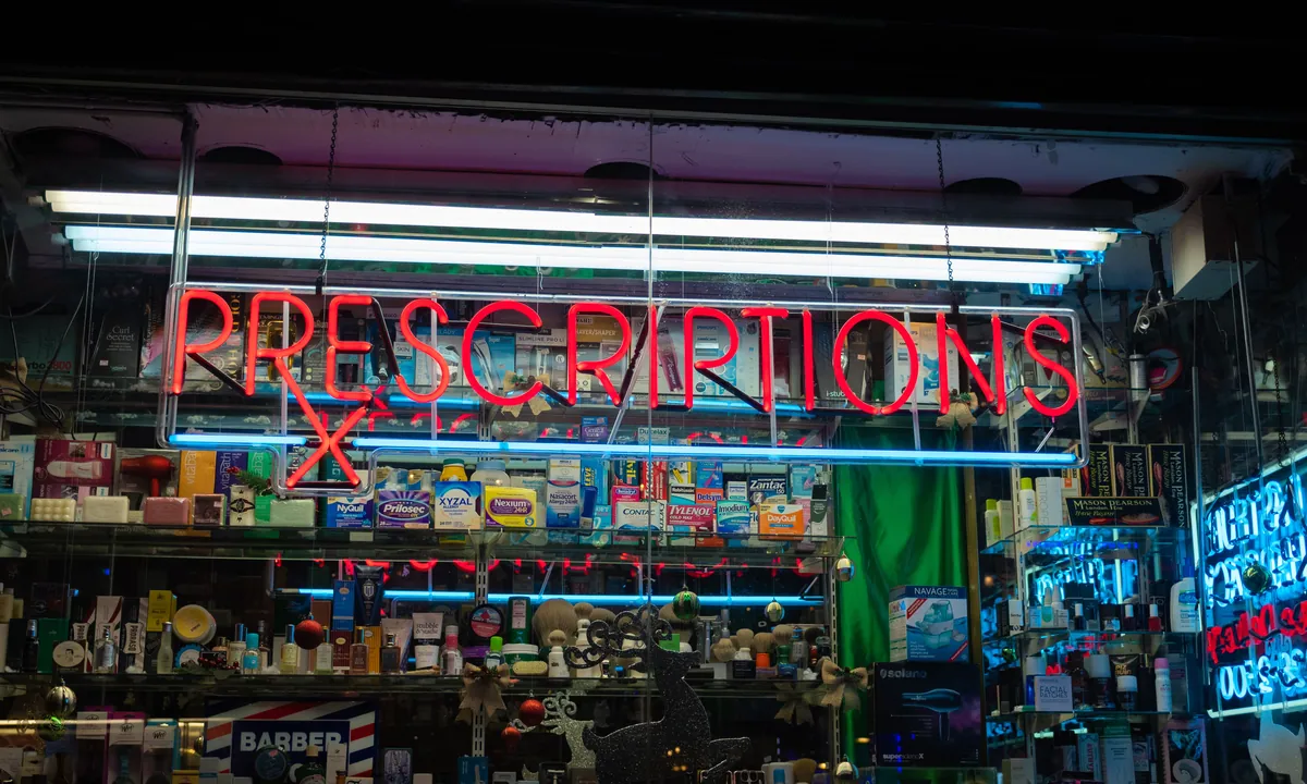 A lit prescriptions sign in a pharmacy window, where patients go to fill opioid prescriptions